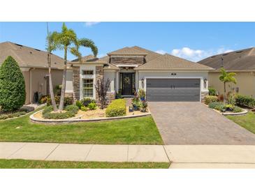 Charming single-story home featuring a well-manicured lawn and a two-car garage at 2554 Stargrass Cir, Clermont, FL 34715