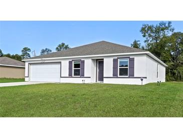 Charming single-story home with a well-manicured lawn, attached garage, and simple, modern design at 2701 Sw 153Rd Ln, Ocala, FL 34473