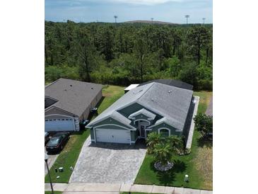 Aerial view of a single-Gathering home showcasing the roof, driveway, and surrounding landscaping at 3620 Benson Park Blvd, Orlando, FL 32829