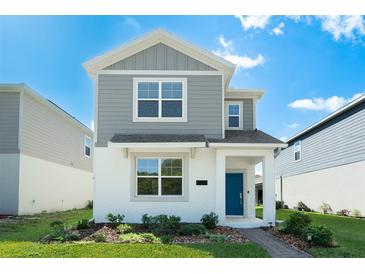 Charming two-story home featuring a modern design, gray siding, white accents and a welcoming blue front door at 6328 Whip O Will Ln, St Cloud, FL 34771