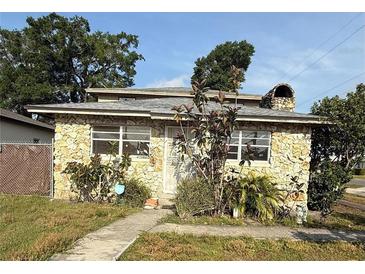 Charming stone-clad home featuring bright windows and a unique stone chimney detail at 702 Willie Mays Pkwy, Orlando, FL 32811