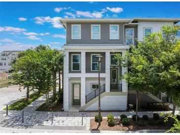 Charming three-story townhome featuring a modern design with lush landscaping and a welcoming entrance at 8478 Karrer Ter, Orlando, FL 32827