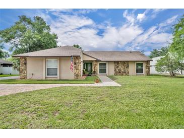 Charming home featuring stone accents, a well-manicured lawn, and welcoming walkway at 150 Tarpon Cir, Winter Springs, FL 32708