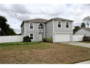 Two-story home with attached two-car garage and fenced yard on an overcast day at 2381 Courtland Blvd, Deltona, FL 32738