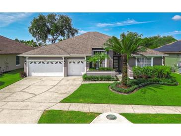 Charming single-story home featuring a manicured front lawn and a spacious two-car garage at 2643 University Acres Dr, Orlando, FL 32817
