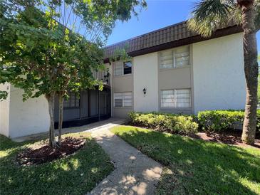 Charming condo building featuring lush landscaping and a welcoming walkway at 51 Windtree Ln # 101, Winter Garden, FL 34787