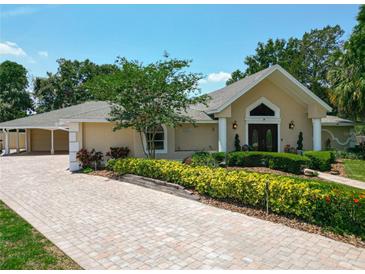 Charming home showcasing its landscaped front yard with a brick driveway at 5852 Medinah Way, Orlando, FL 32819