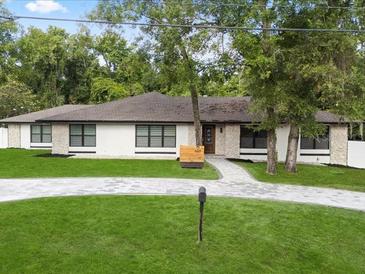A charming one-story home boasts a well-manicured front yard and beautiful stone accents at 625 N Central Ave, Oviedo, FL 32765