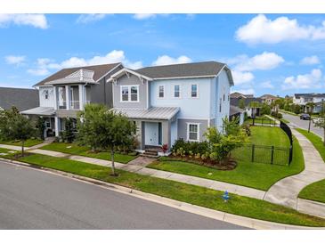 Charming two-story home featuring a landscaped yard, complemented by blue sky and manicured lawn at 6875 Bridgman St, Orlando, FL 32827