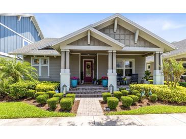 Charming home featuring manicured landscaping, covered porch, and a red front door at 13701 Chauvin Ave, Orlando, FL 32827