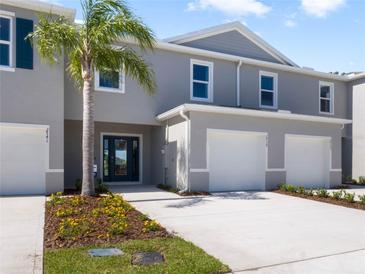 Charming townhome featuring a two-car garage, manicured lawn, and a welcoming entrance, all bathed in sunlight at 2710 Golden Trout Ln, Edgewater, FL 32141
