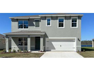 Charming two-story home showcasing a modern gray exterior, white trim, and a two-car garage at 279 Wisteria Ct, Deltona, FL 32738