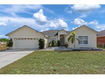 Charming single-story home featuring a well-maintained lawn and attached two-car garage at 322 Huron Dr, Kissimmee, FL 34759