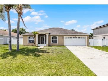 Charming single-story home with a well-maintained lawn, two-car garage, and inviting entryway at 460 Flamingo Ct, Kissimmee, FL 34759