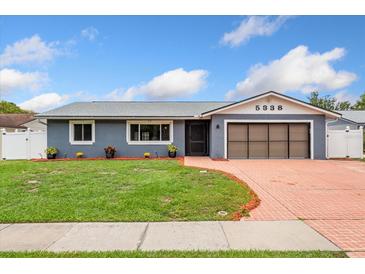 Charming single-story home featuring a brick driveway, gray facade and well-maintained lawn at 5338 Tangerine Ave, Winter Park, FL 32792