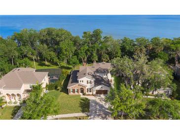 Stunning aerial view of the property with lush green surroundings, partial lake view, and a screened in pool at 557 Lake Cove Pointe Cir, Winter Garden, FL 34787