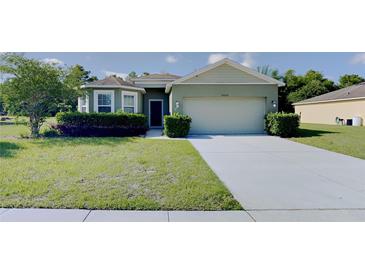 Inviting single-story home with a well-manicured lawn and a two-car garage at 7806 Tanbier Dr, Orlando, FL 32818