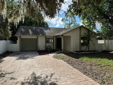 Charming single-story home featuring a brick driveway and well-maintained landscaping, set beneath mature trees at 3739 S Fern Creek Ave, Orlando, FL 32806