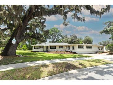 Charming single-story home featuring manicured lawn, mature oak trees and freshly painted exterior at 656 Lake Charm Dr, Oviedo, FL 32765