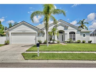 Charming single-story home with a lush front lawn and mature palm trees at 1034 Alvina Ln, Oviedo, FL 32765