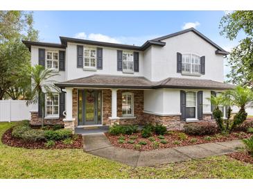 Beautiful two-story home with stone accents, a covered front porch, and a well-manicured lawn at 141 Dommerich Dr, Maitland, FL 32751