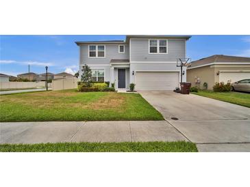 Charming two-story home featuring a well-maintained lawn and attached two-car garage at 2203 Bluebird Pl, St Cloud, FL 34771