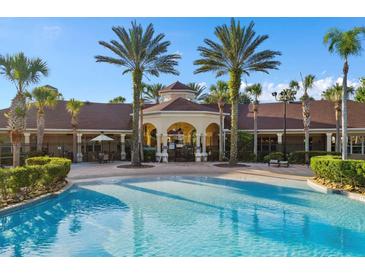 Community pool with clear blue water, palm trees, and clubhouse providing a resort-style living experience at 2778 Almaton Loop # 302, Kissimmee, FL 34747