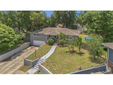 Charming single-story home with a well-manicured front yard, integrated garage, and mature trees creating a private setting at 300 Hickory Ct, Apopka, FL 32712
