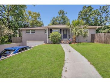 Charming home with a well-manicured lawn, gray brick, and inviting walkway at 300 Hickory Ct, Apopka, FL 32712