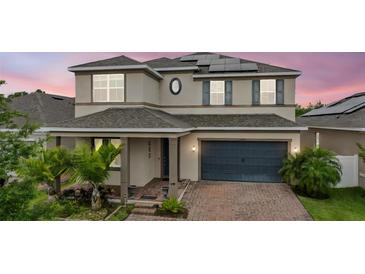 Charming two-story home with a well-maintained front yard, brick driveway, and solar panels on the roof at 4783 Riverwalk Dr, St Cloud, FL 34771