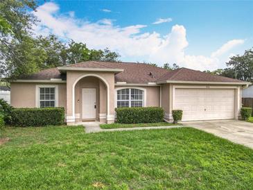 Charming single-story home with a manicured lawn and attached two-car garage at 970 Courtland Blvd, Deltona, FL 32738