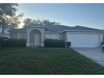 Charming single-story home featuring a lush lawn, manicured shrubs, and an attached two-car garage at 970 Courtland Blvd, Deltona, FL 32738