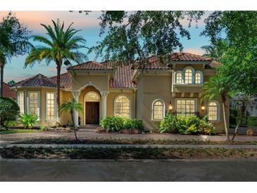 Charming home featuring a red tile roof, lush landscaping, and an inviting front entrance with archways at 1070 Henley Downs Pl, Lake Mary, FL 32746