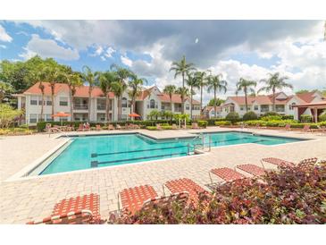 Resort-style pool area with palm trees and plenty of lounge chairs for relaxing by the water at 11526 Westwood Blvd # 735, Orlando, FL 32821