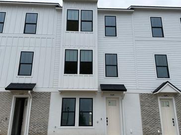 New construction townhome exterior featuring white siding, modern windows, and individual entryways at 15089 Grove Lake Dr, Winter Garden, FL 34787