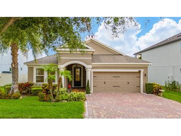 Charming single-story home with a well-manicured lawn and a welcoming arched entryway leading to the front door at 15862 Citrus Grove Loop, Winter Garden, FL 34787