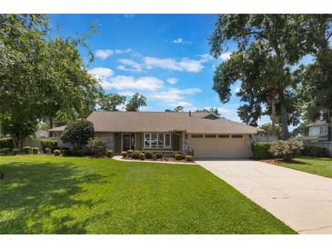 Charming one-story home features a well-manicured lawn, mature trees, and a neutral exterior color scheme at 3300 Se 22Nd Ave, Ocala, FL 34471