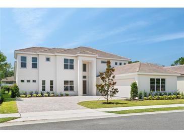 Stunning two-story home featuring a brick driveway, manicured lawn, and a neutral color palette at 6125 Village Edge Pl, Sanford, FL 32771