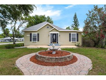 Charming home featuring a manicured lawn with a lovely decorative fountain feature at the entrance at 803 Jersey Ave, St Cloud, FL 34769