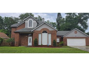 Charming two-story brick home with landscaped yard, mature trees and a two car garage at 8612 Valley Ridge Ct, Orlando, FL 32818