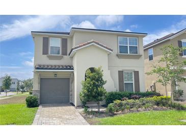 Charming two-story home with a well-maintained lawn and neutral-colored stucco exterior at 8940 Coconut Breeze Dr, Kissimmee, FL 34747