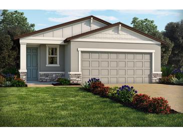 Charming single-story home with a two-car garage and beautifully landscaped front yard with vibrant flowers at 903 Donahue Pass, Lake Hamilton, FL 33851