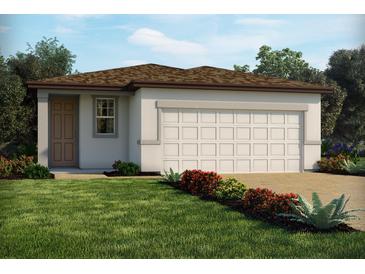 Charming one-story home featuring a two-car garage, well-manicured lawn, and colorful landscaping at 909 Donahue Pass, Lake Hamilton, FL 33851