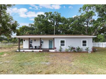 Charming single-story home with a covered front porch and a combination of white and gray exterior at 1341 W Belmar St, Lakeland, FL 33815