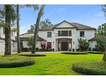 Stunning home with lush landscaping, mature trees, and a grand double-door entrance at 1455 Kelso Blvd, Windermere, FL 34786
