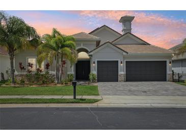 Charming single-Gathering home featuring a three-car garage, lush landscaping, and a well-manicured lawn at sunset at 2586 Lancaster Ridge, Davenport, FL 33837