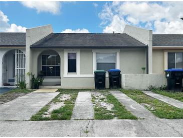 Modest single-story home with a stucco exterior, concrete driveway, and neatly maintained landscaping at 2716 Upsandown St, Orlando, FL 32837