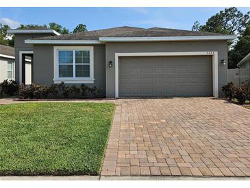Charming single-story home with a well-maintained lawn and a two-car garage with brick paver driveway at 3265 Stratton Cir, Kissimmee, FL 34744