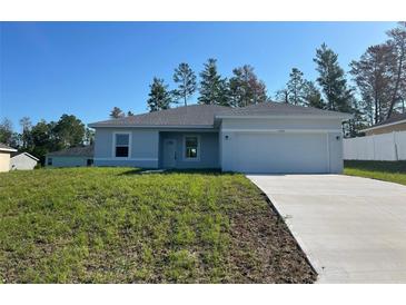 Charming one-story home with a well-manicured lawn and a two-car garage at 5153 Sw 159Th St, Ocala, FL 34473