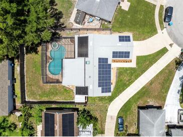 Aerial view of home featuring a screened pool and solar panels for energy efficiency at 525 Southport Dr, Longwood, FL 32750
